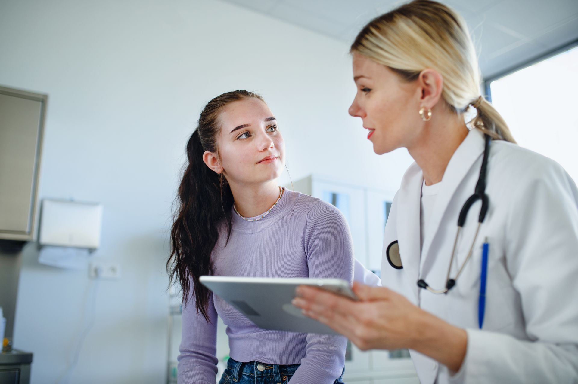 Doctor providing confidential reproductive health information to a young woman at a clinic.