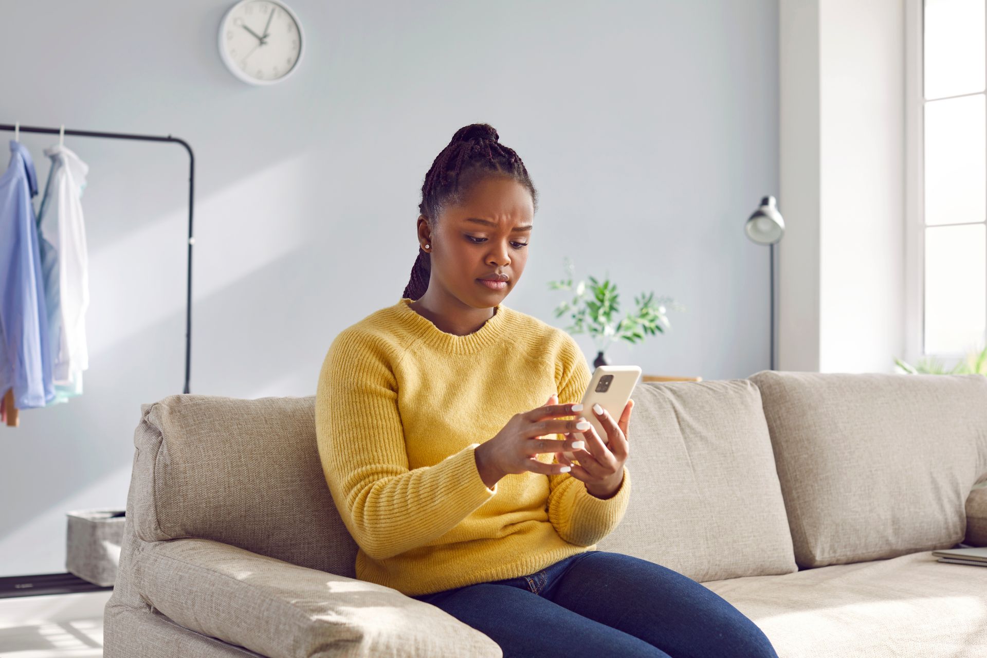 Woman looking at phone with concern, seeking answers and support for unexpected pregnancy decisions