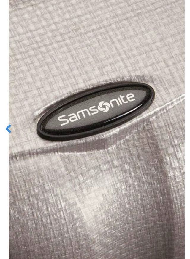 Primo piano del logo Samsonite su un tessuto grigio testurizzato.