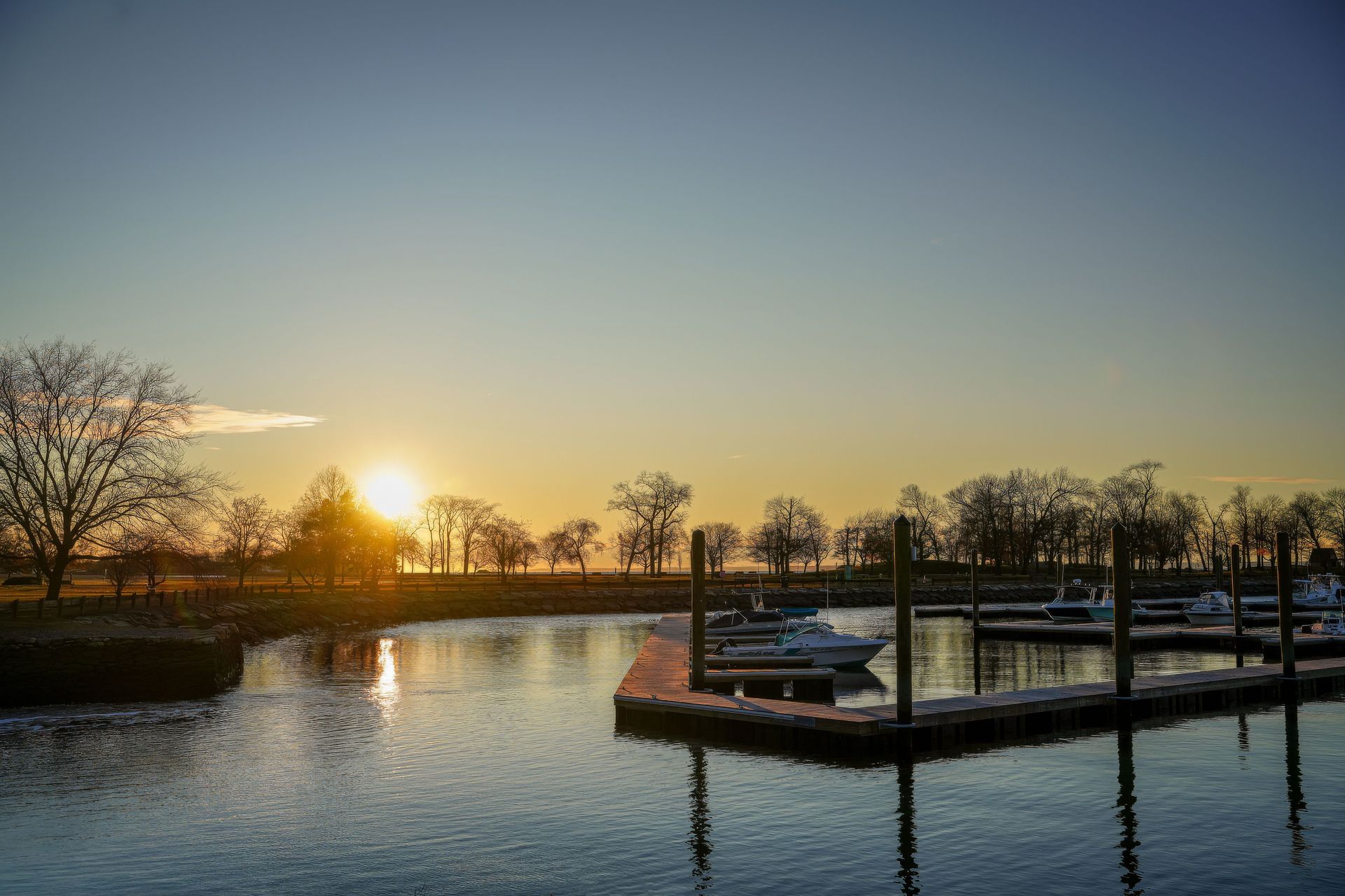 Boats docked at a marina at sunset