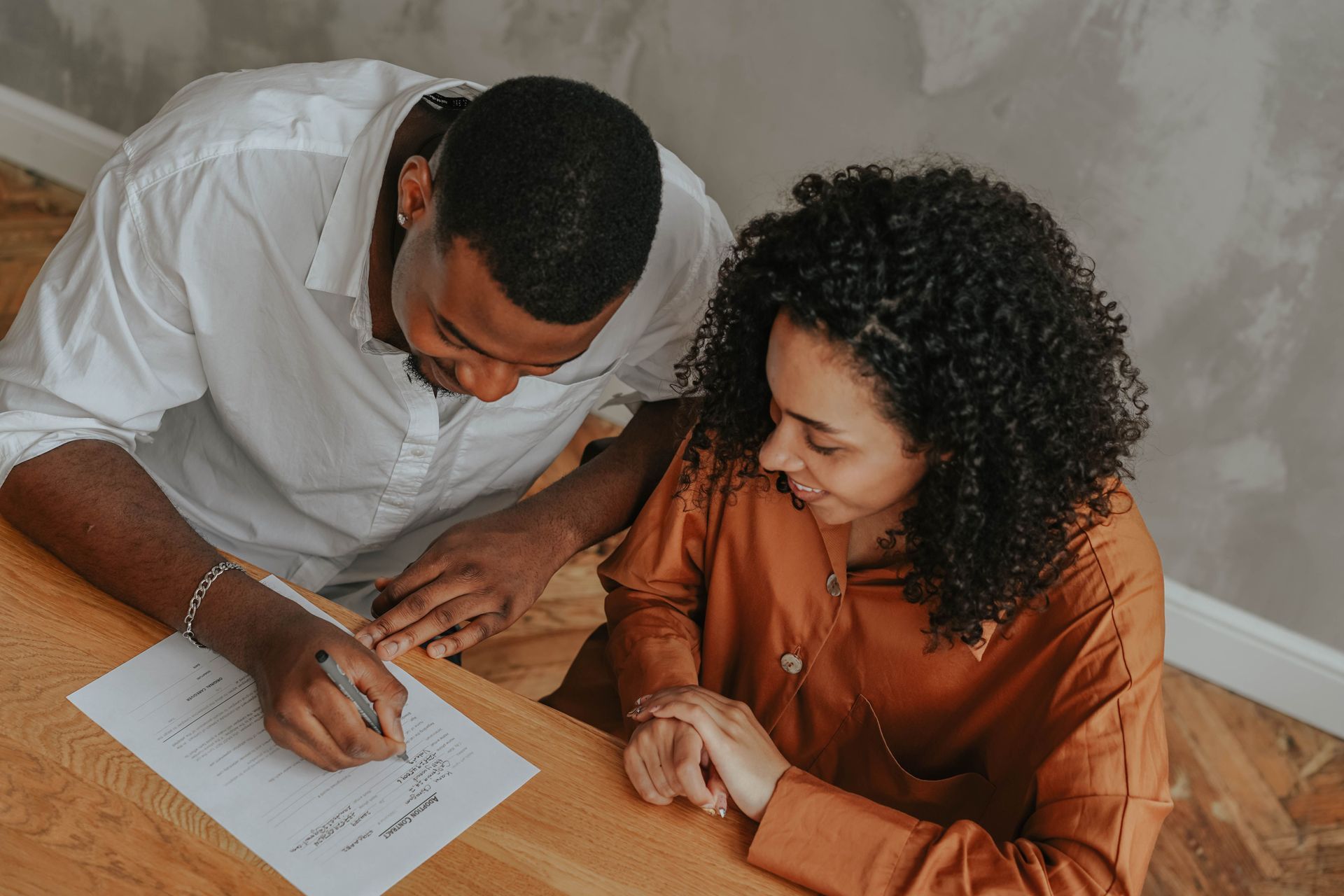A couple reviewing and signing paperwork together at home