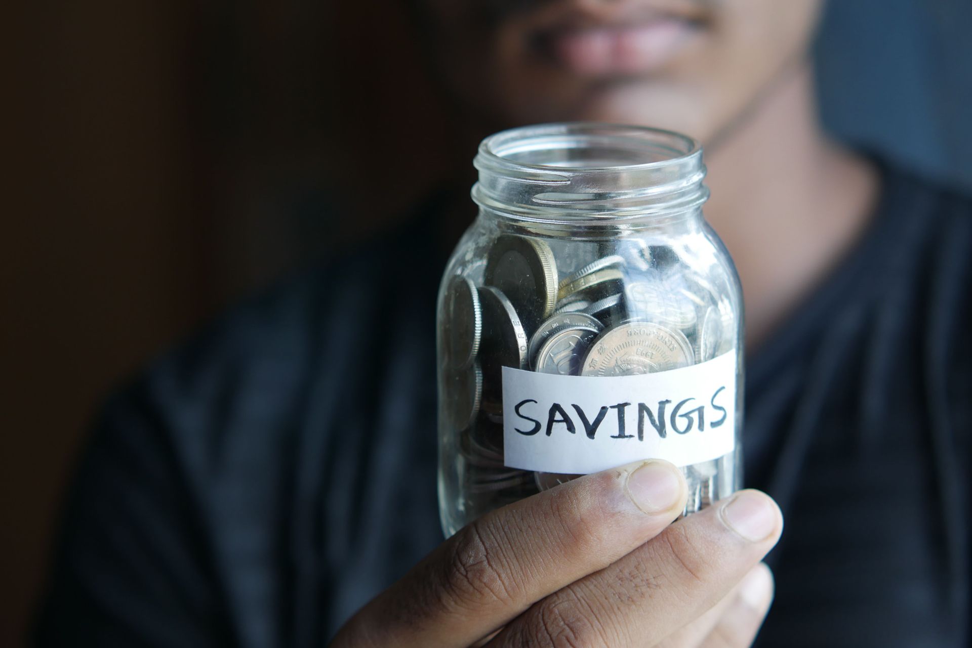 Coins in a glass jar labeled savings