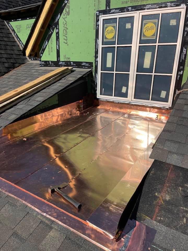 A copper roof with a window on top of it