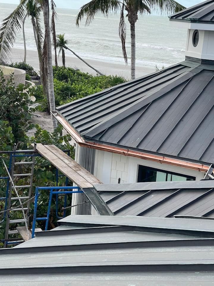 A house with a roof that is being built with a view of the ocean.