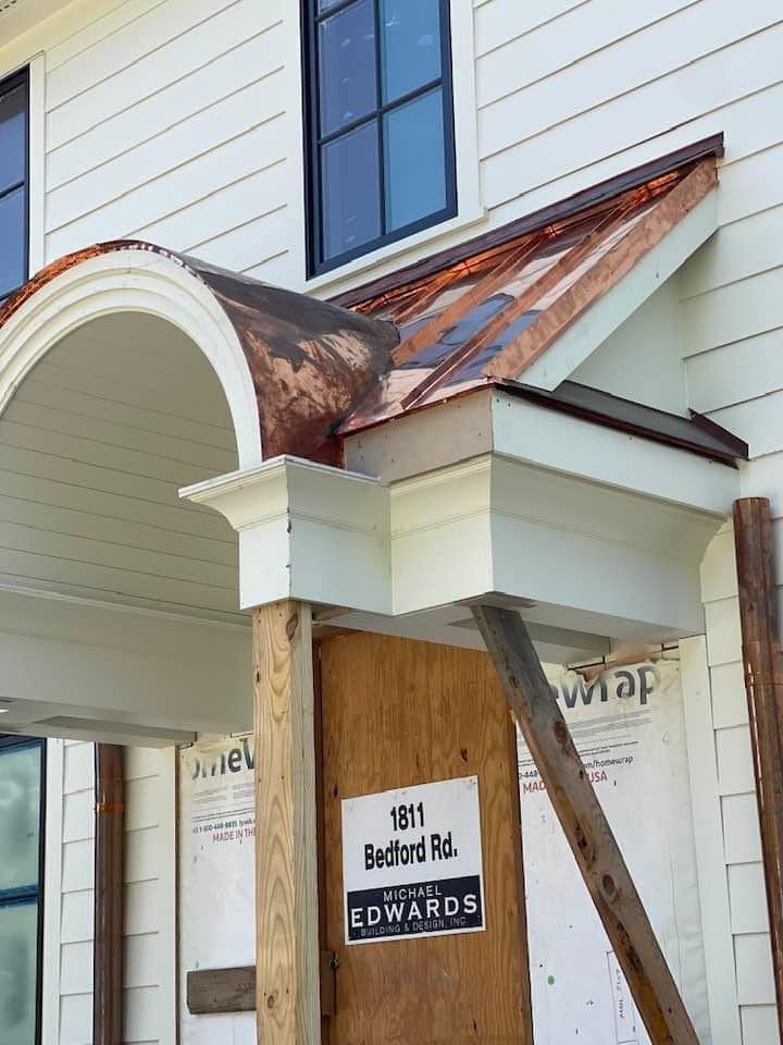 A white house with a copper roof and a sign that says edwards