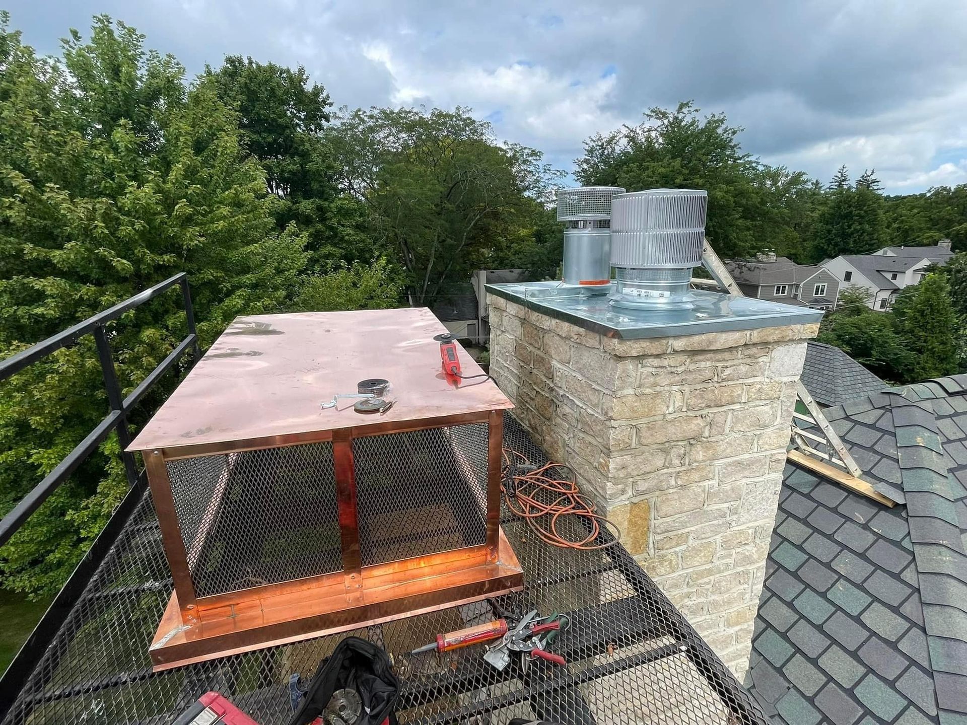A chimney is being installed on the roof of a house.
