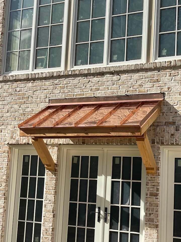 A brick building with a copper canopy over a door