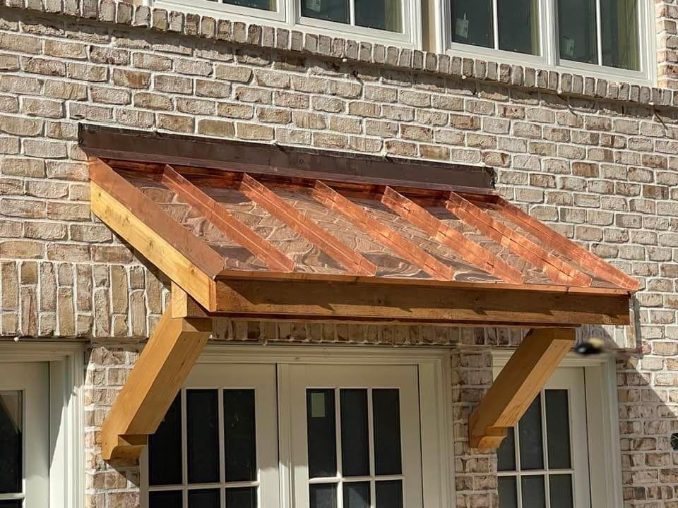 A brick building with a wooden canopy over a door