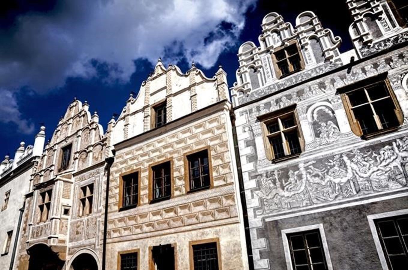 Row of historic European buildings with ornate facades, under a blue sky.