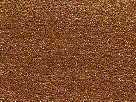 A close-up, textured surface with a warm, metallic bronze or dark copper appearance featuring fine, gritty particles.