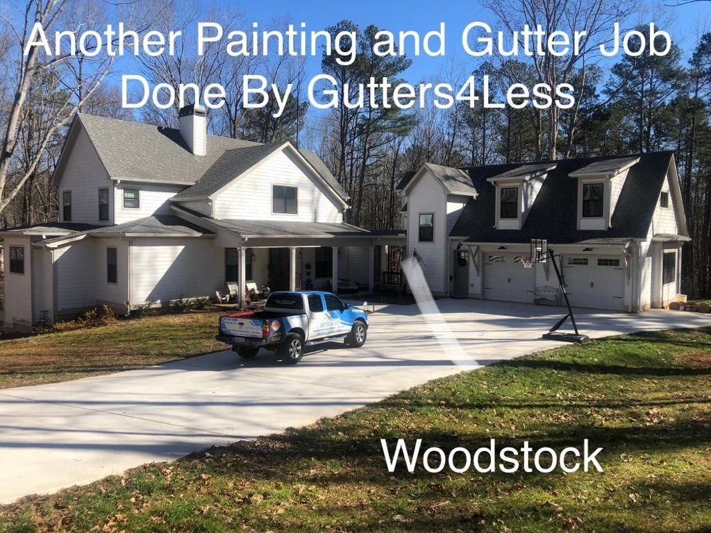 A white house with a driveway and garage, featuring a pickup truck and text about a job by Gutters4Less in Woodstock.