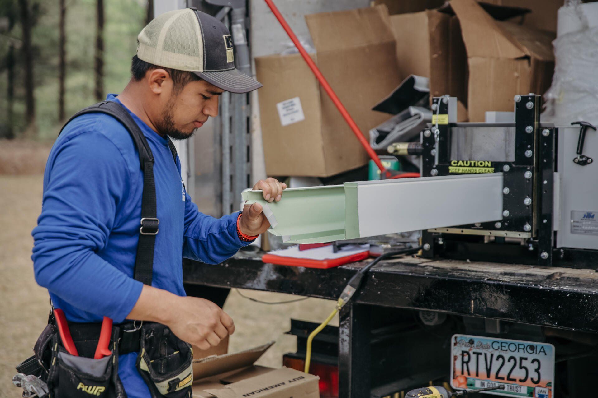 A man is working on a piece of equipment in the back of a truck.