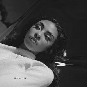 Black-and-white portrait of a woman reclining and looking upward, wearing a light top