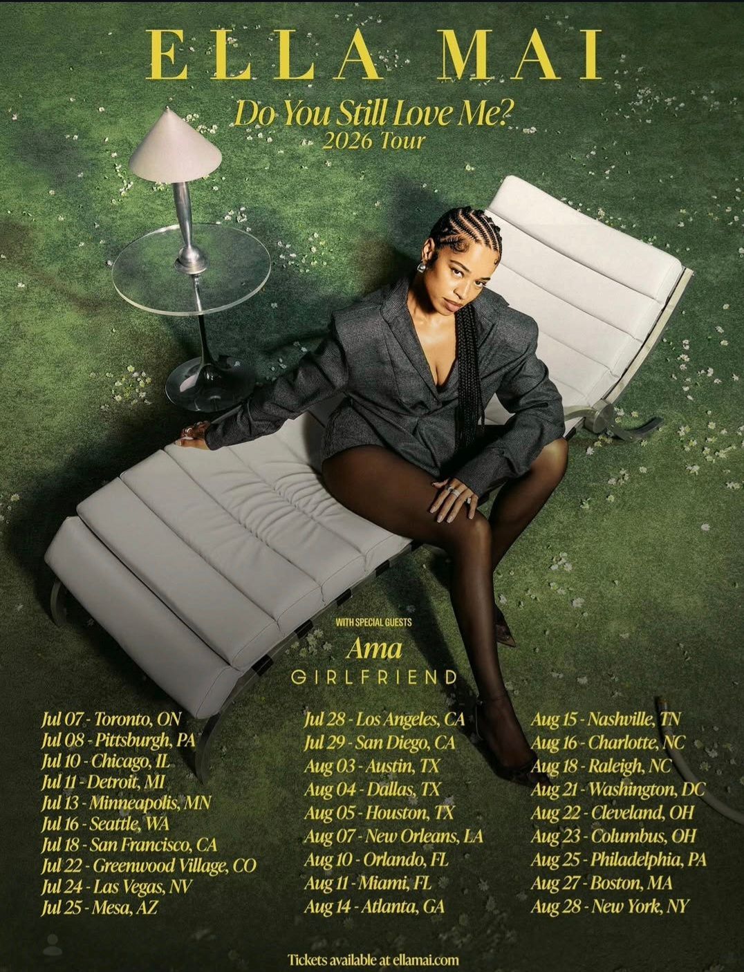 Ella Mai seated on a white lounge chair in a green room, with gold text and a lamp beside her.