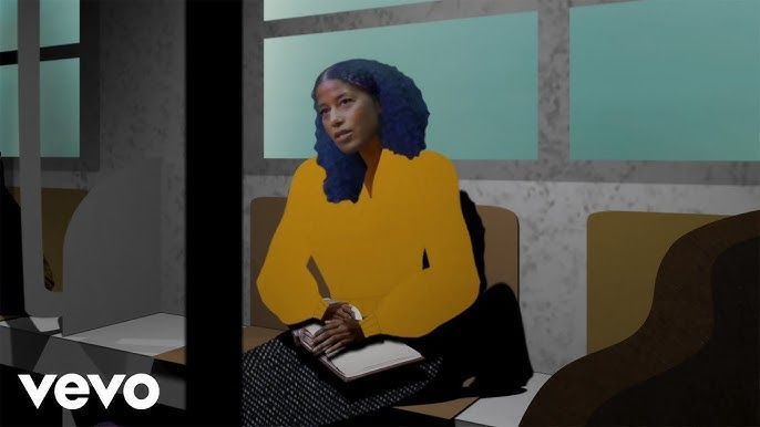 Woman in a yellow top writing in a notebook, seated by a window in a modern room.