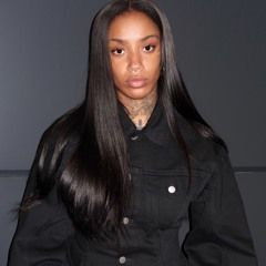 Portrait of a person with long straight hair wearing a black jacket against a dark background