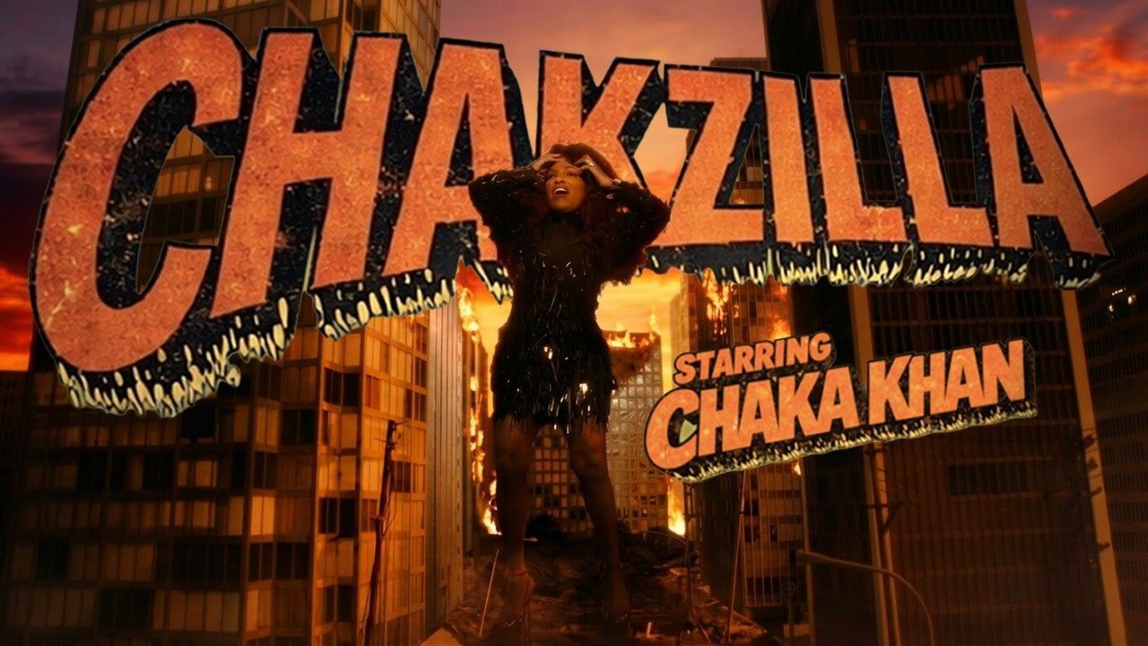 Orange CHAKZILLA sign with Godzilla-like figure and “Starring Chaka Khan” on a city building at night