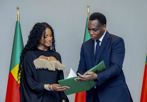 Two officials reviewing a document beside green and red flags