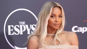 Woman with long blonde hair on an ESPYS red carpet, wearing a strapless beige dress.