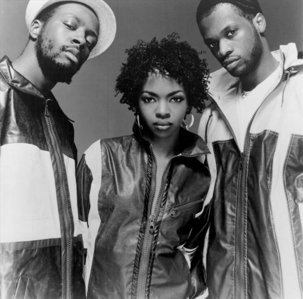 Three people posing in black-and-white, wearing streetwear and looking at the camera.