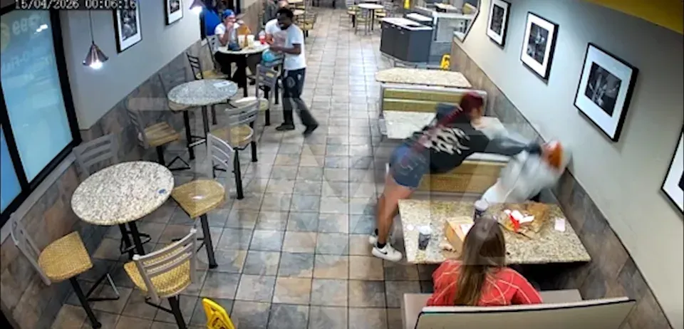 Cafeteria scene with people at tables; one person appears to slip or fall near a bench.