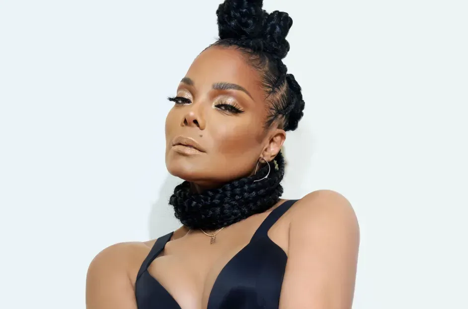 Portrait of a woman in a black top with an elegant braided updo against a light background