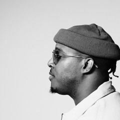 Black-and-white side profile portrait of a man wearing glasses and a knit beanie, facing left.