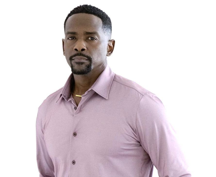 Portrait of a man in a light pink button-up shirt against a white background