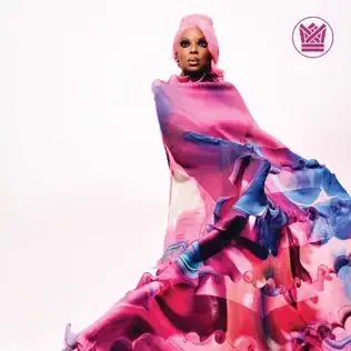 Model in a pink and blue flowing gown and headwrap against a white background