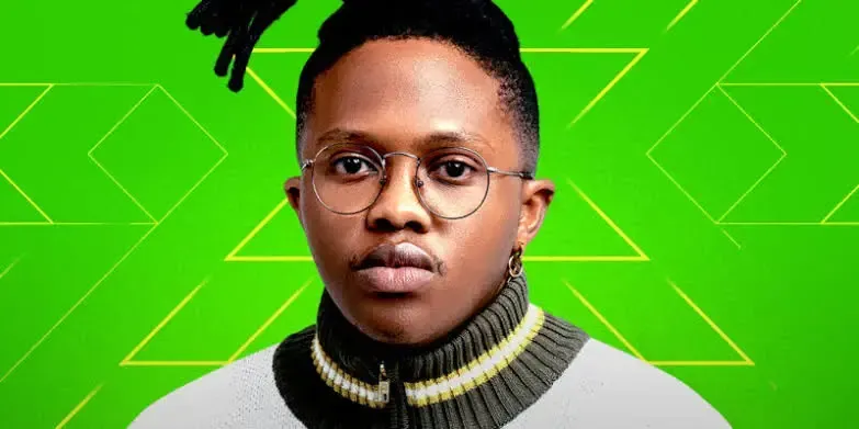 Portrait of a man with glasses and a striped turtleneck against a bright green geometric background