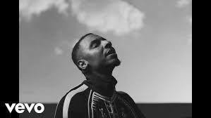Black-and-white shot of a man looking up at the sky, with a Vevo logo in the corner.