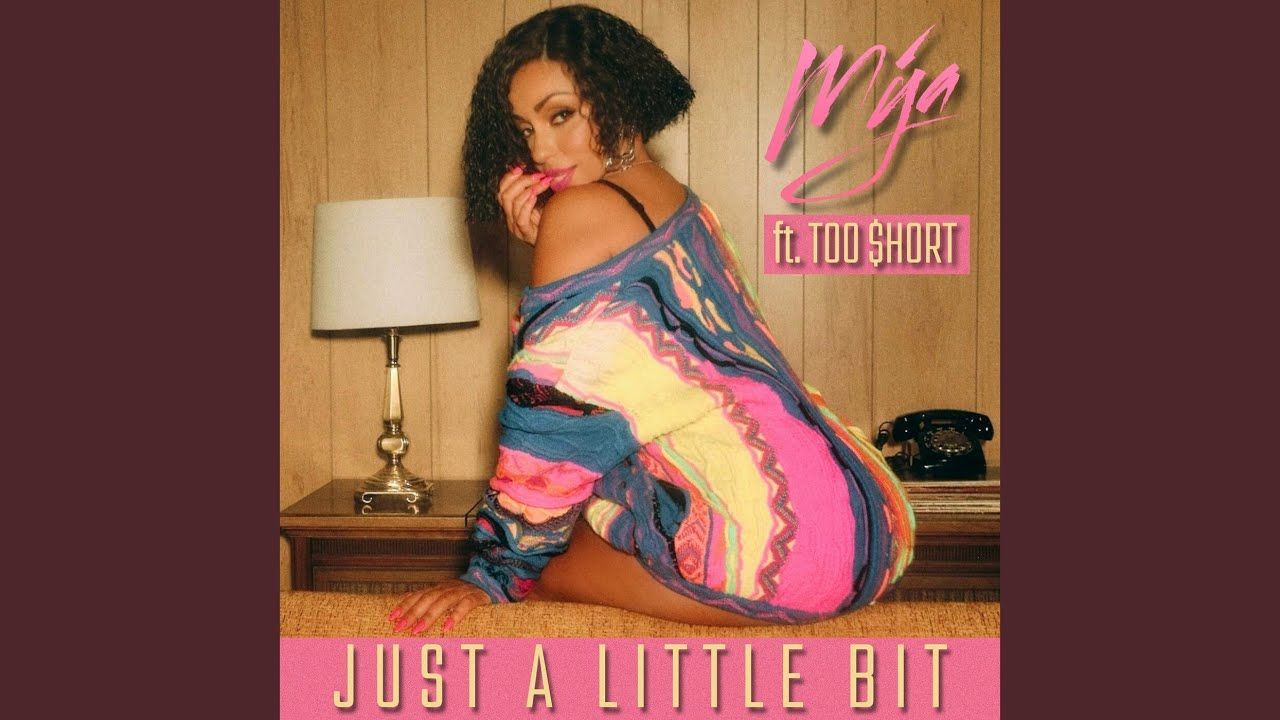 Album cover of a woman in a colorful dress kneeling beside a lamp, with “Just a Little Bit” text.