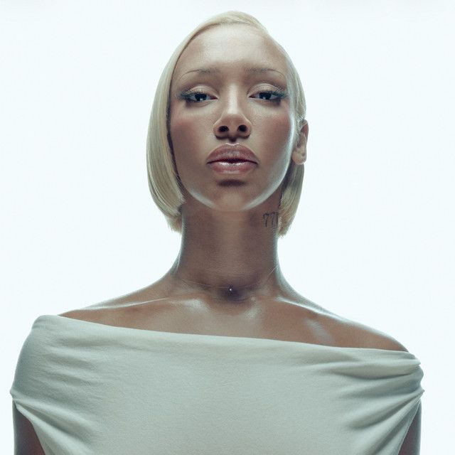 Portrait of a person in a white off-shoulder top against a light background