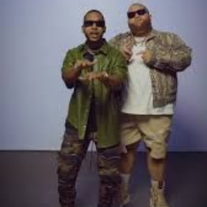 Two people posing in casual streetwear and sunglasses against a plain backdrop.