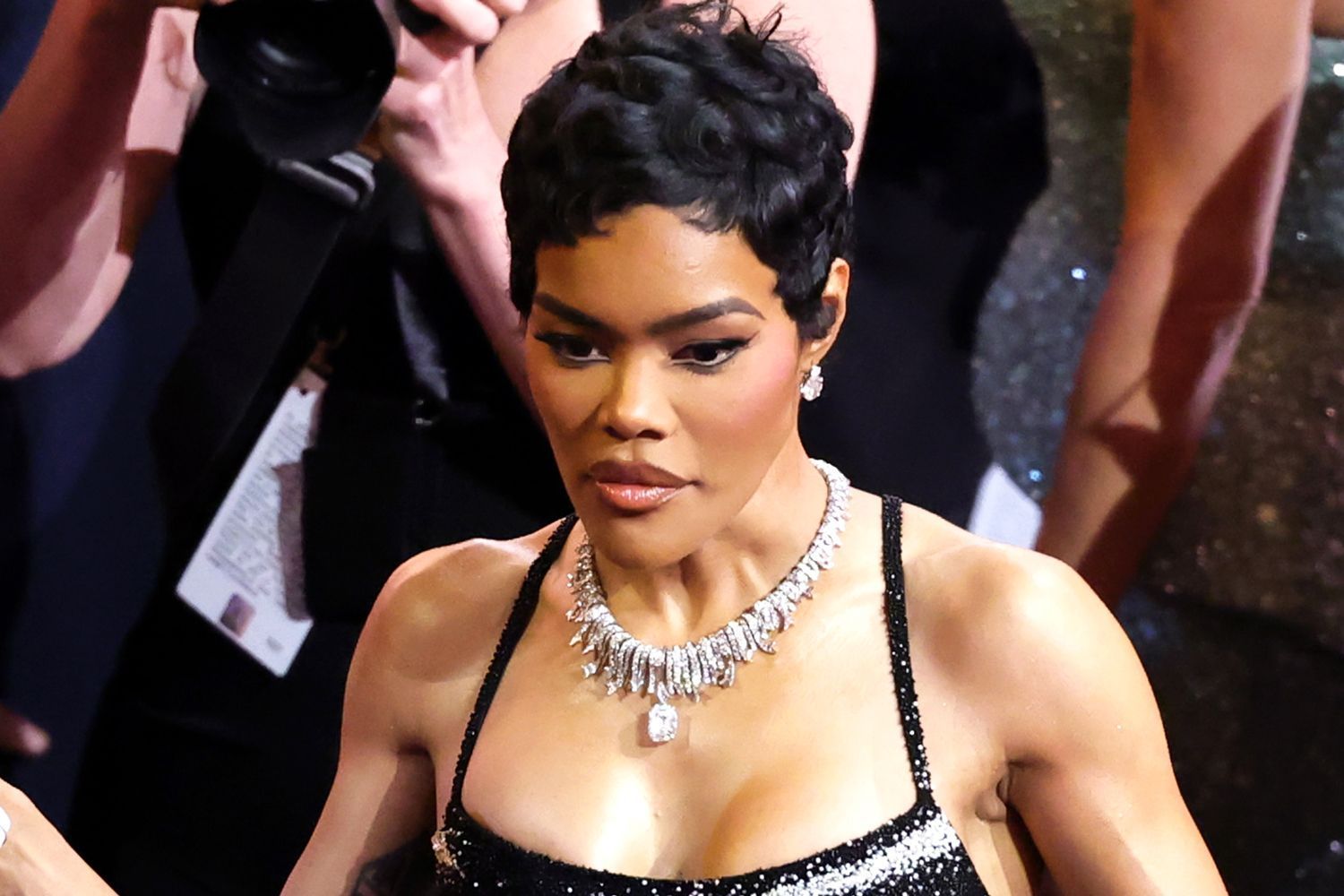 Close-up of a woman in a black dress and diamond necklace at a red carpet event