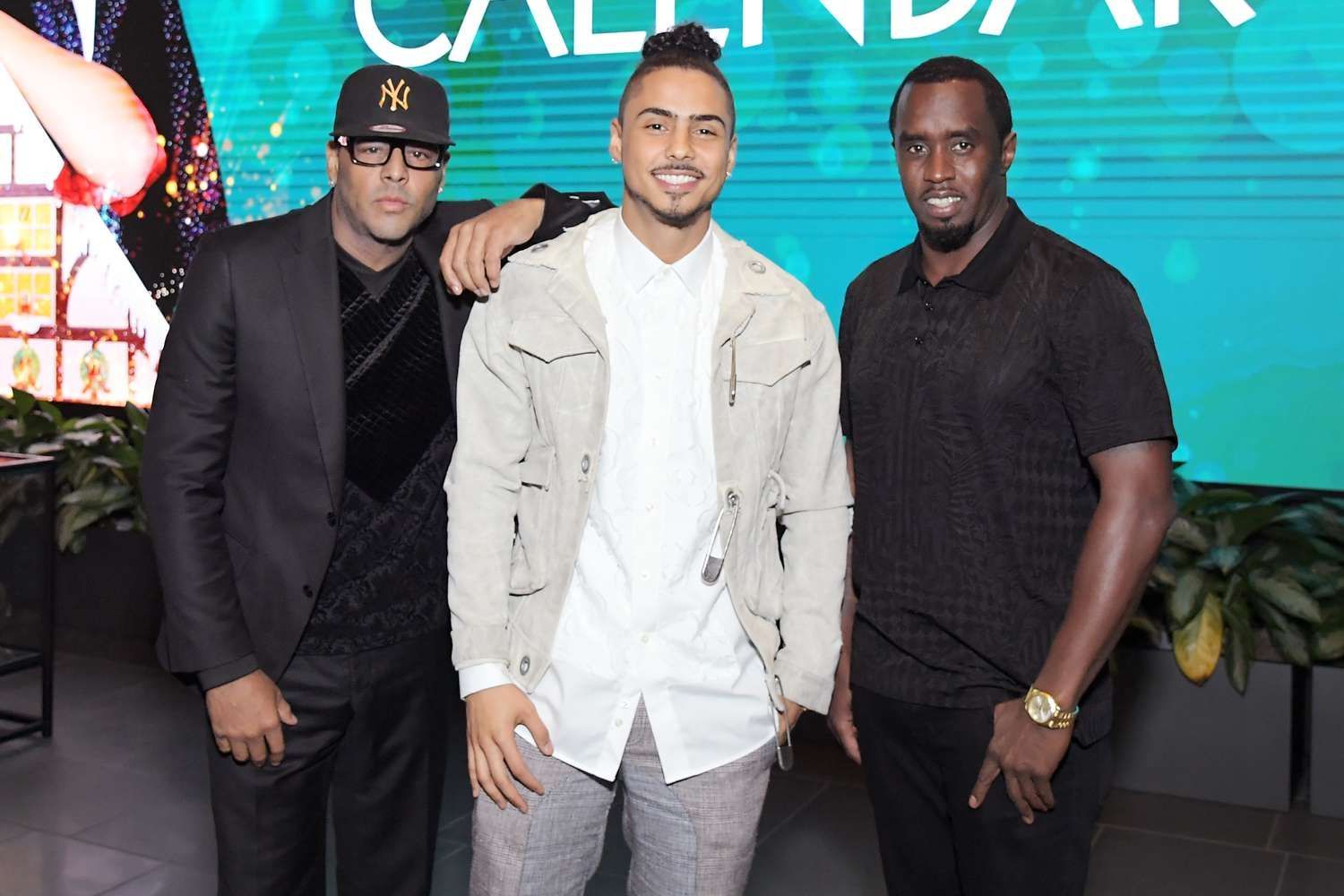 Three men posing at an event in front of a teal “Calendar” backdrop.