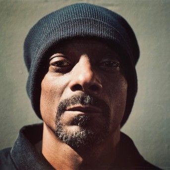 Close-up portrait of a man in a dark knit beanie against a plain background