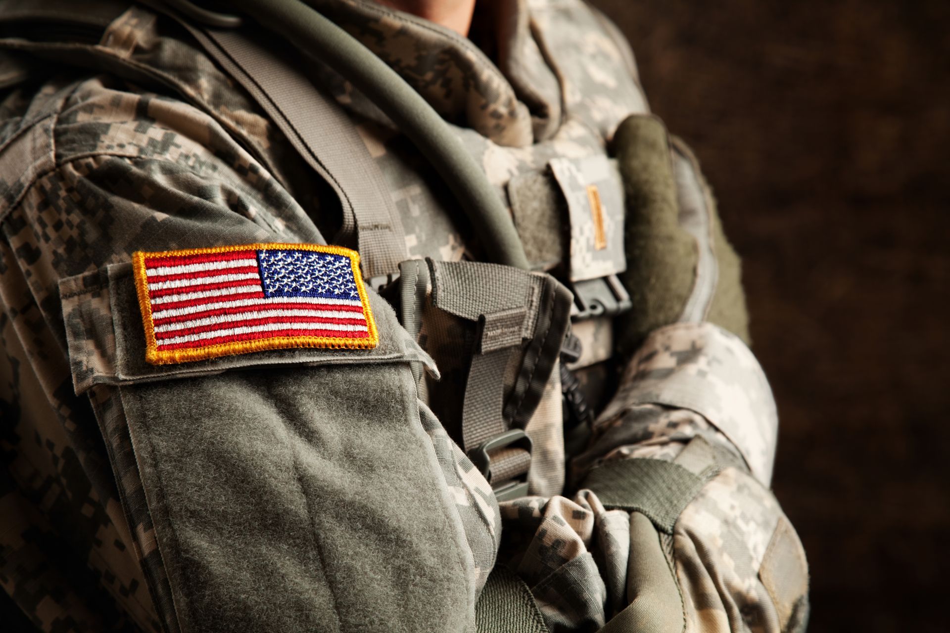 A close up of a soldier 's arm with an american flag on it.