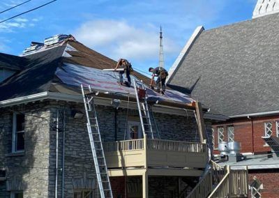 Un groupe de personnes travaille sur le toit d'un immeuble.