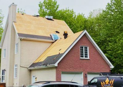Une voiture est garée devant une maison en cours de rénovation.