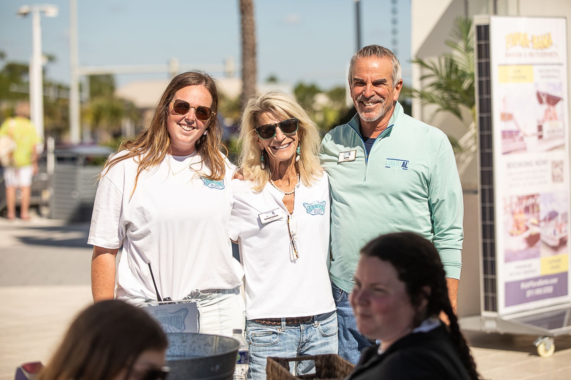Three happy staff members standing outside Coastal Orange Beach at Gumbo Fest
