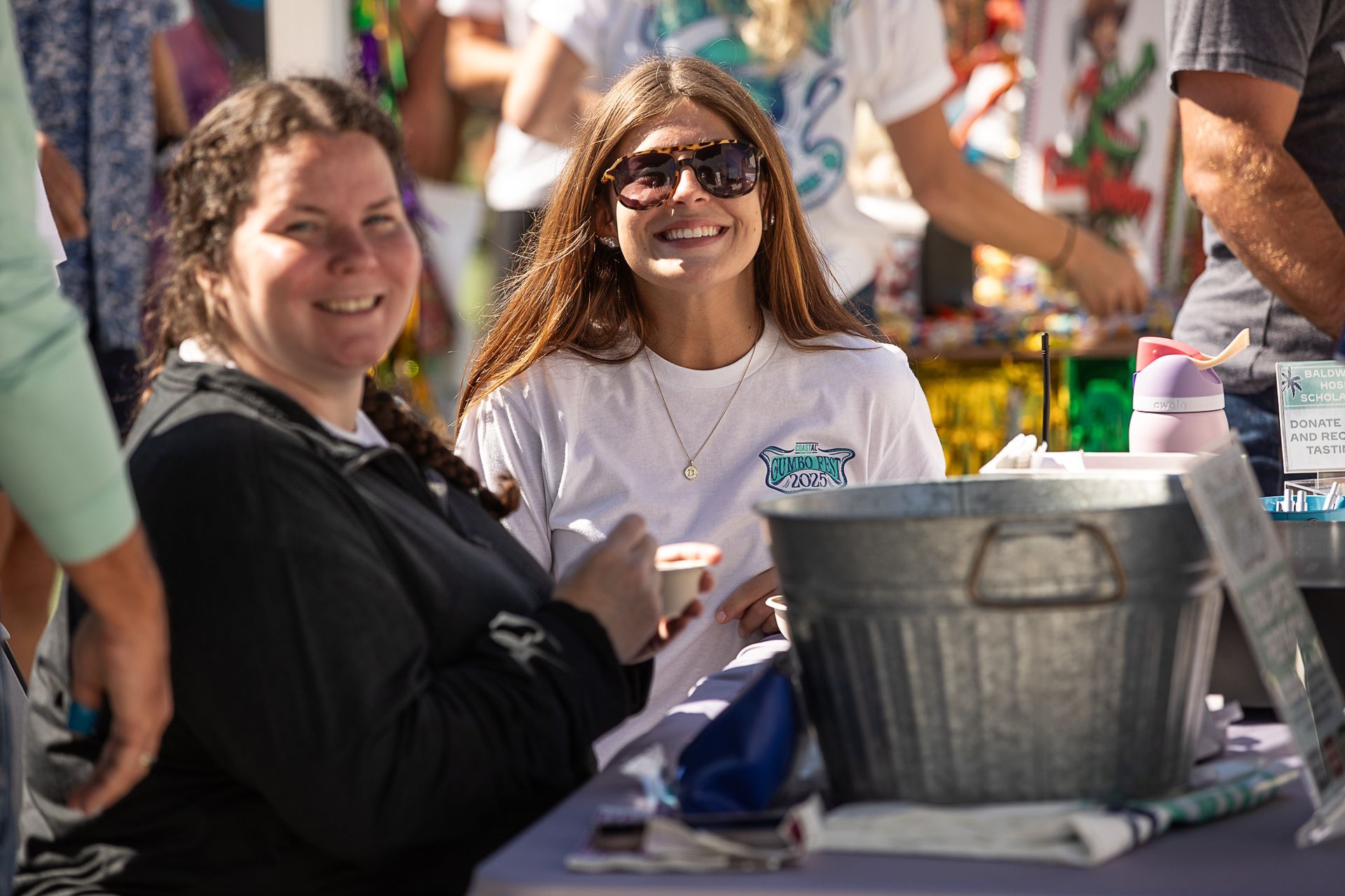 Two smiling people checking people in at Gumbo Fest