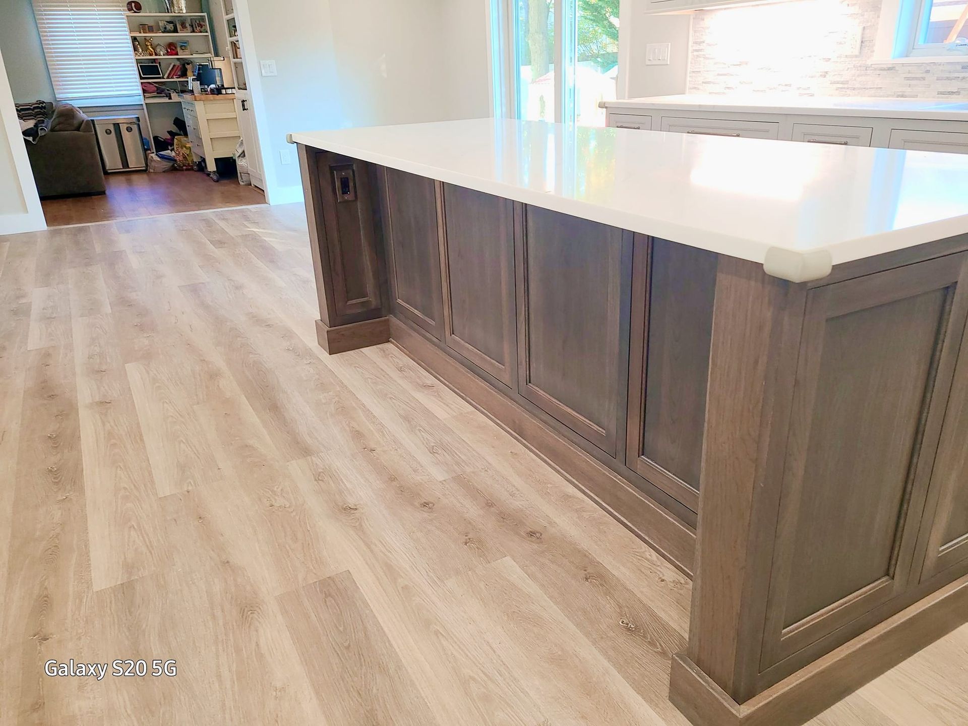 A kitchen with a large island and a white counter top.