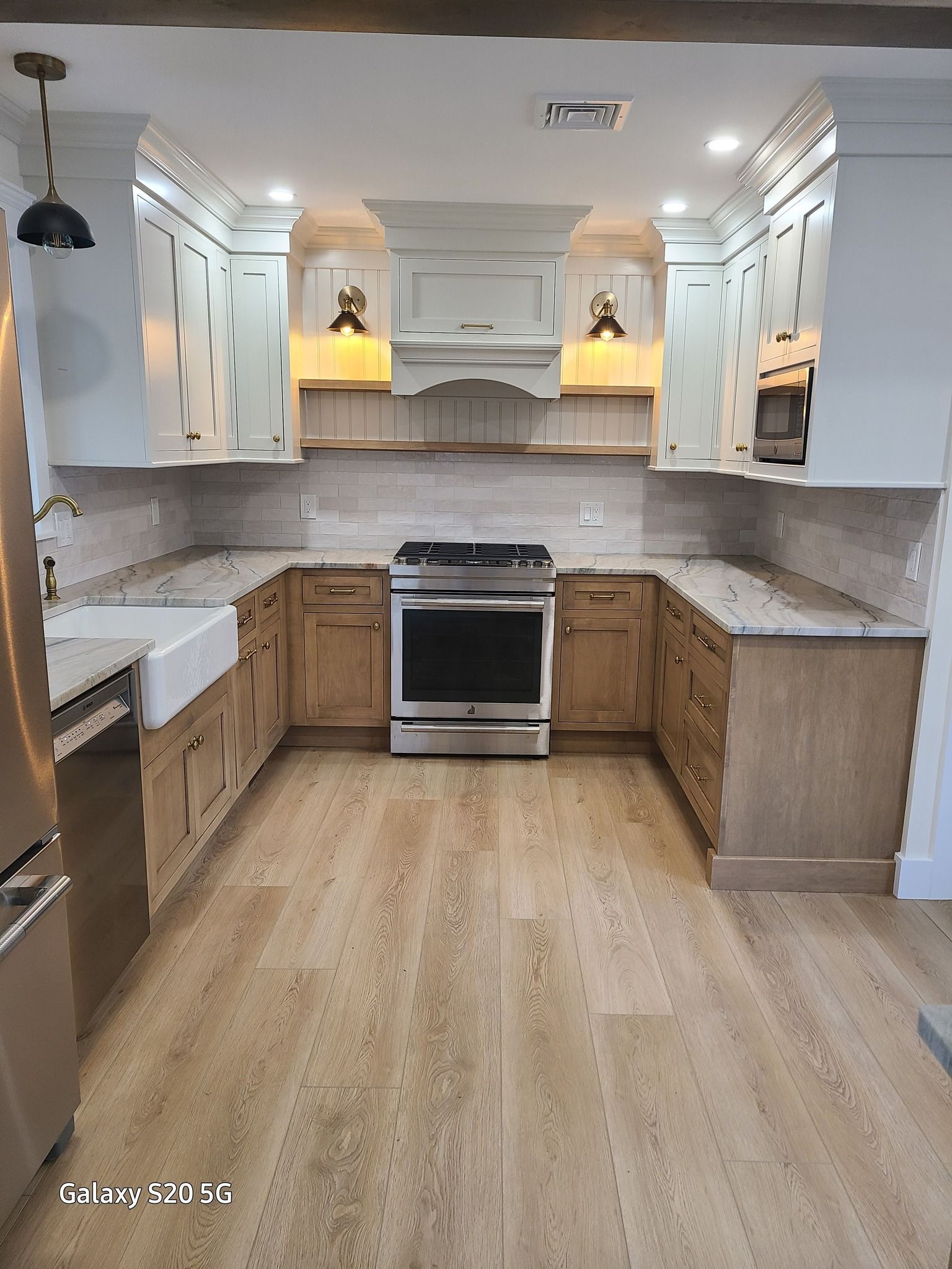 A kitchen with stainless steel appliances and wooden cabinets.