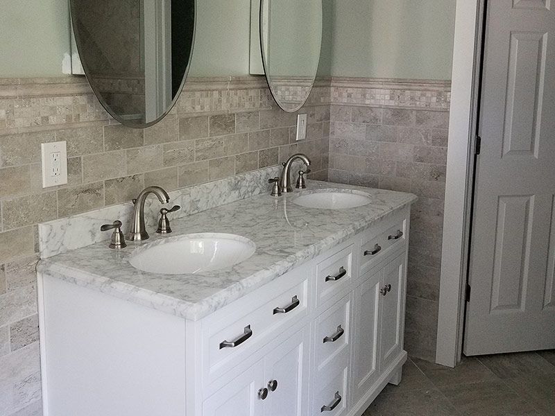 A bathroom with two sinks and two mirrors.