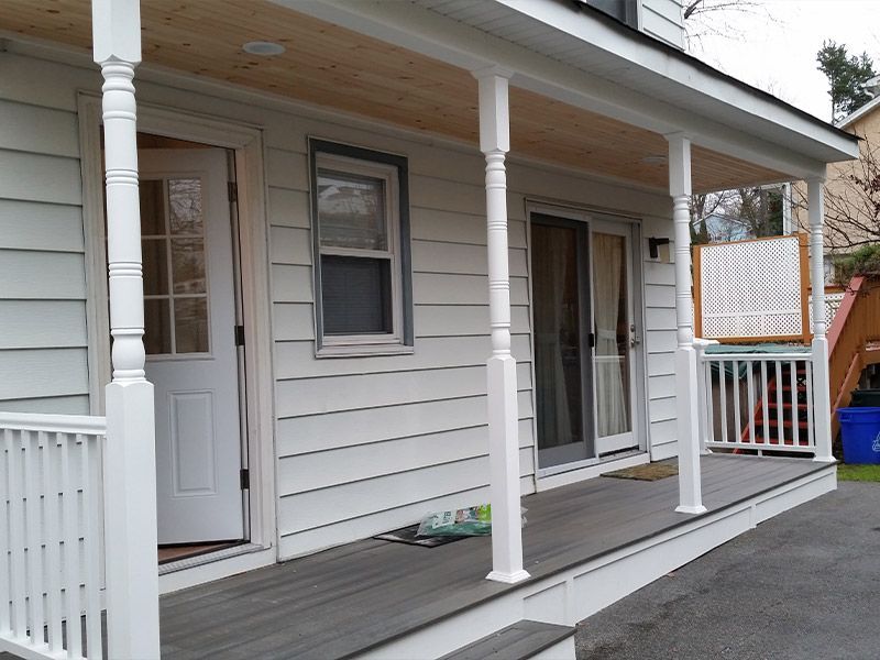 A white house with a porch and a sliding glass door