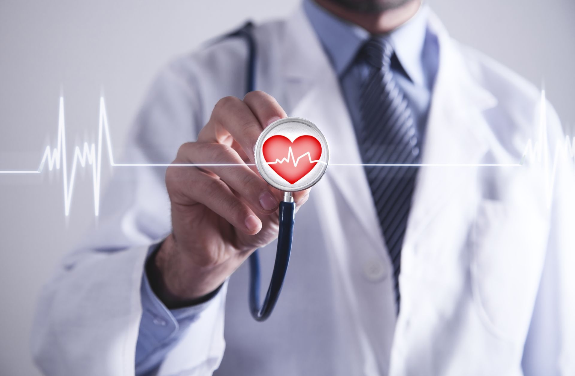 Doctor holding a stethoscope with heart icon and ECG line, symbolizing heart health.