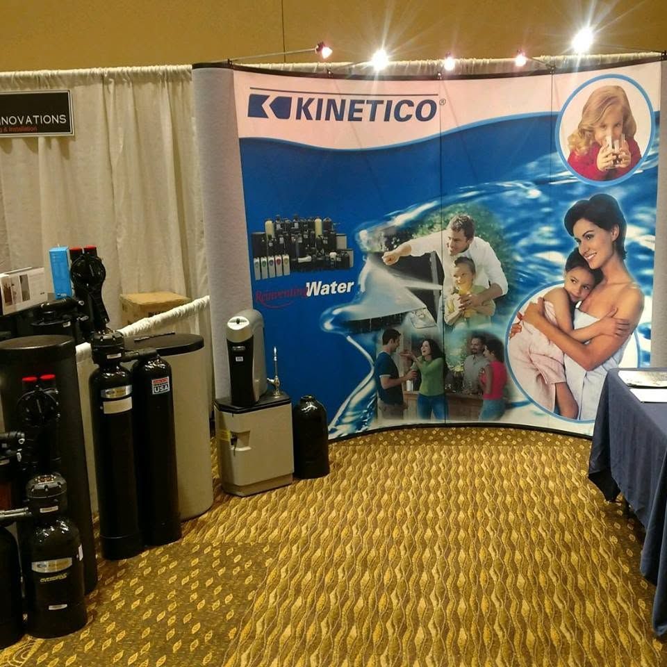 Kinetico trade show booth with water filtration displays and a large blue promotional backdrop