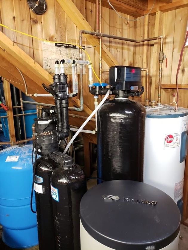 Water softening and filtration tanks and equipment installed in a utility room under stairs