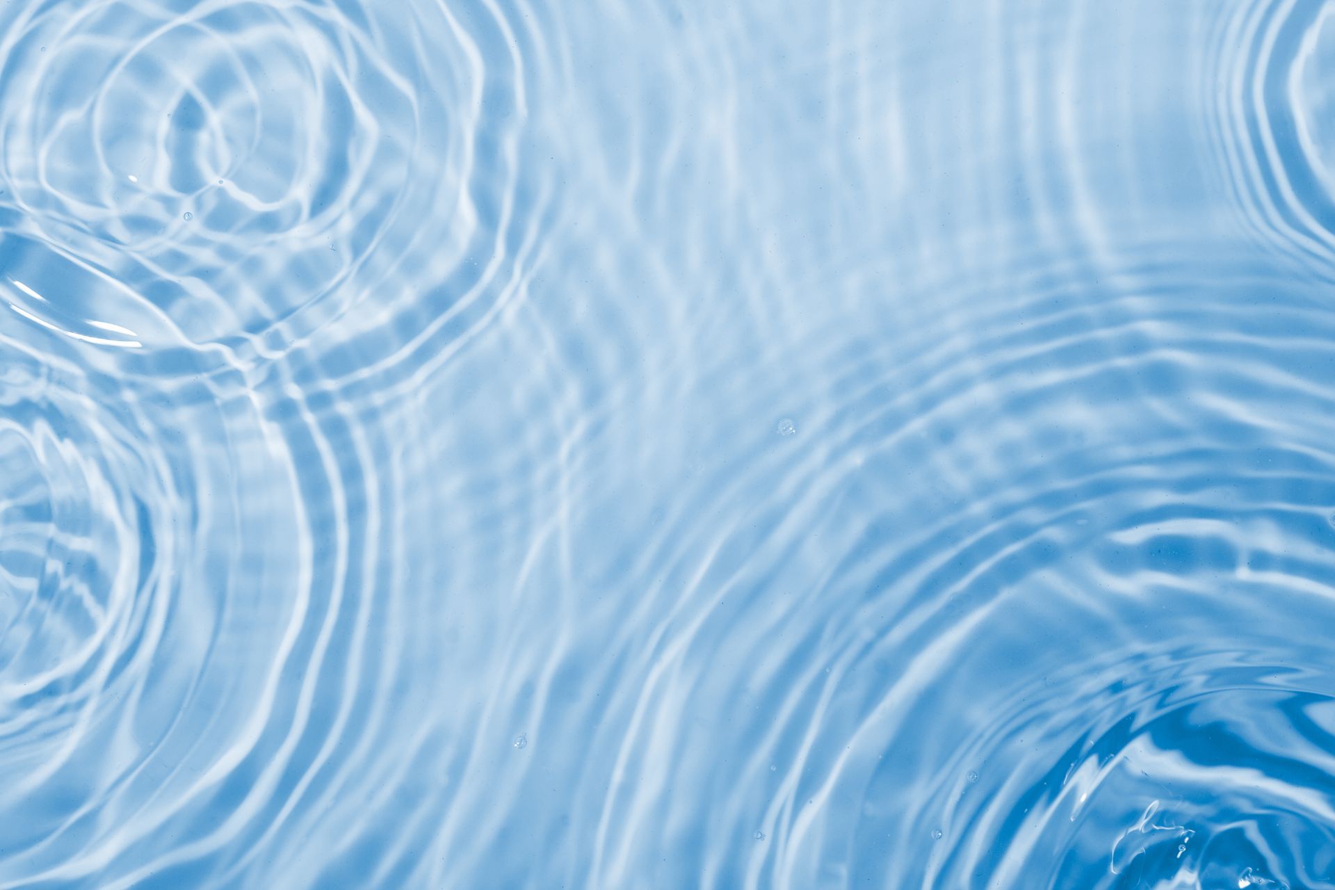 Light blue water ripples with overlapping circular wave patterns